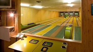 A bowling alley with lanes, a bowling ball return, and a pinsetter. - Landgasthof Tarp (Tarp)