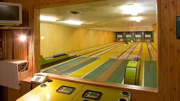 Une salle de bowling avec des pistes, un système de retour des boules et un appareil de redressement des quilles.