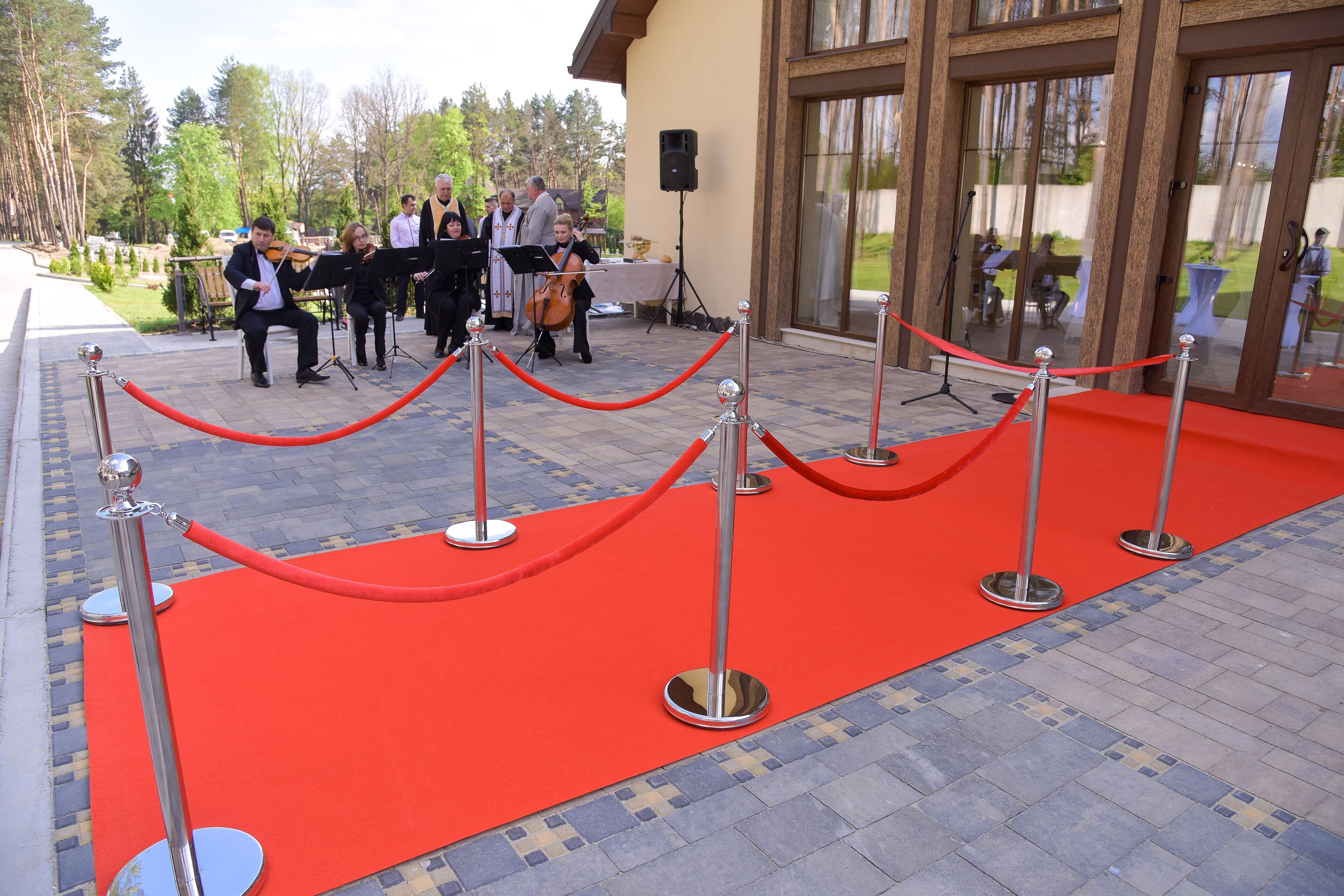 A red carpet leading to a building entrance with a group of musicians performing.