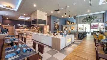 A modern restaurant with a central island, wooden flooring, and contemporary lighting fixtures.