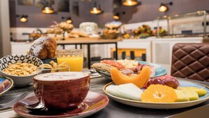 Ein Frühstückstisch mit verschiedenen Speisen, darunter Obst, Brot und einem Getränk.