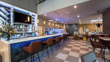 Eine Bar mit kariertem Boden, Barhocker und einer Theke, an der ein Fernseher steht.