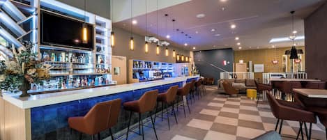 A bar area with a checkered floor, bar stools, and a counter with a TV.