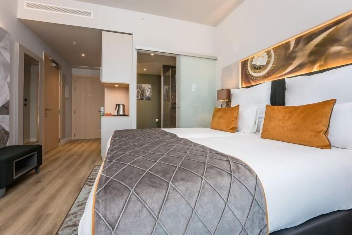 Een hotelkamer met een groot bed, een bureau en een garderobe.