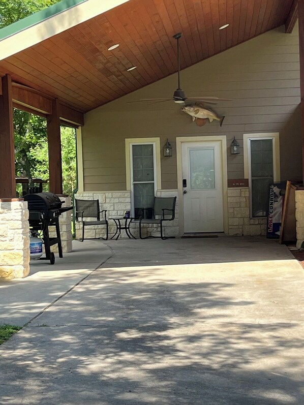 A covered patio area with a grill, outdoor seating, and a ceiling fan. - West Wing at the Manor w/ Swimming Pond & Sand Volleyball Access (Montgomery)