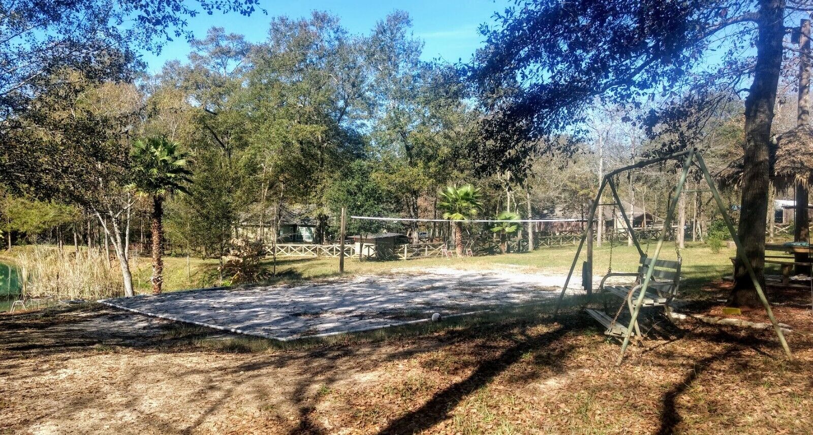 A covered outdoor area with a swing set and a trampoline.