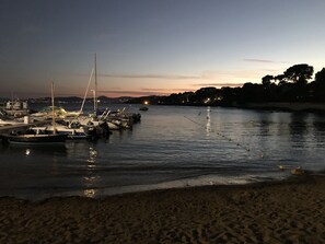 A marina with boats docked at night, calm water, and a beach in the foreground. - Beautiful house, air-conditioned, private pool, very quiet, 10-minute walk from the beach (Saint-Raphaël)