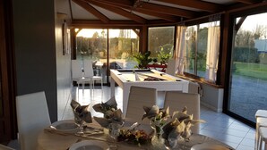 Comedor con una mesa preparada para cuatro, ventanas amplias y vistas al exterior.