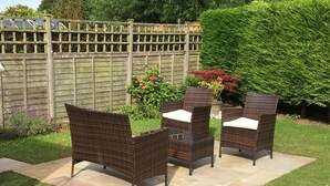 An outdoor seating area with wicker furniture and a stone patio. - Yorkshire Wolds Spacious Modern Holiday Bungalow (Driffield)