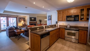 A modern kitchen with wooden cabinets, stainless steel appliances, and a central island. - Comfortable 1 Bedroom Slopeside Condo - No Cleaning Fee! by RedAwning (Crested Butte)