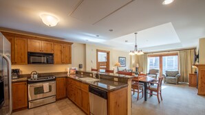 Une cuisine moderne avec des meubles en bois, des appareils en acier inoxydable et un îlot central.