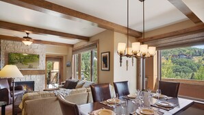 A dining area with a wooden table set for six, a fireplace, and a view of the outdoors. - Edgemont 2508 Luxury On Mountain Condo With Ski-In/Ski-Out Access! (Steamboat Springs)