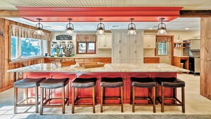 A kitchen with a large island, bar stools, pendant lights, and wooden cabinetry. - Endless Family Fun @ Private LUX Retreat Sleeps 25 (Annville)