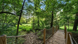 A wooden bridge with a rope railing, surrounded by lush greenery and trees. - Endless Family Fun @ Private LUX Retreat Sleeps 25 (Annville)