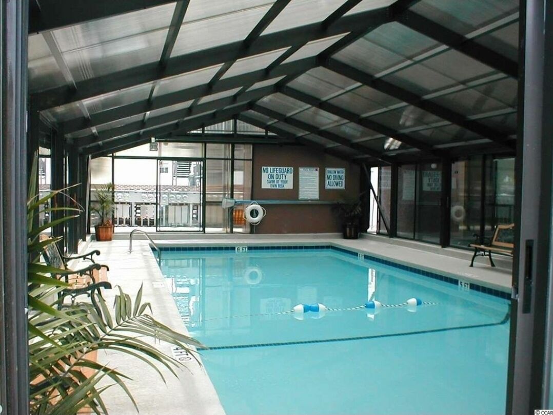 An indoor swimming pool with a covered roof, clear signage, and a view of the outside. - Just steps away from the beach!  (Myrtle Beach)