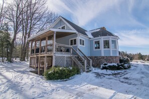 Une maison à deux étages, dotée d’un porche couvert et de fondations en pierre.