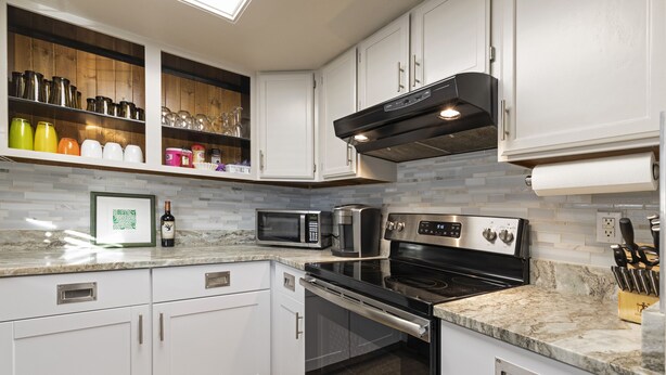 A modern kitchen with white cabinets, a stainless steel range, a microwave, and a built-in oven. - Spectacular Condo In Downtown Whitefish, Close To Glacier Park, Skiing And Golf (Whitefish)