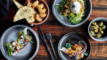 A table with various dishes, including seafood, salads, and a bowl of olives.