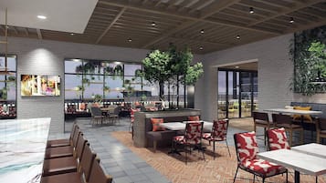 A modern indoor dining area with brick flooring, wooden ceiling beams, and large windows offering views of the cityscape.