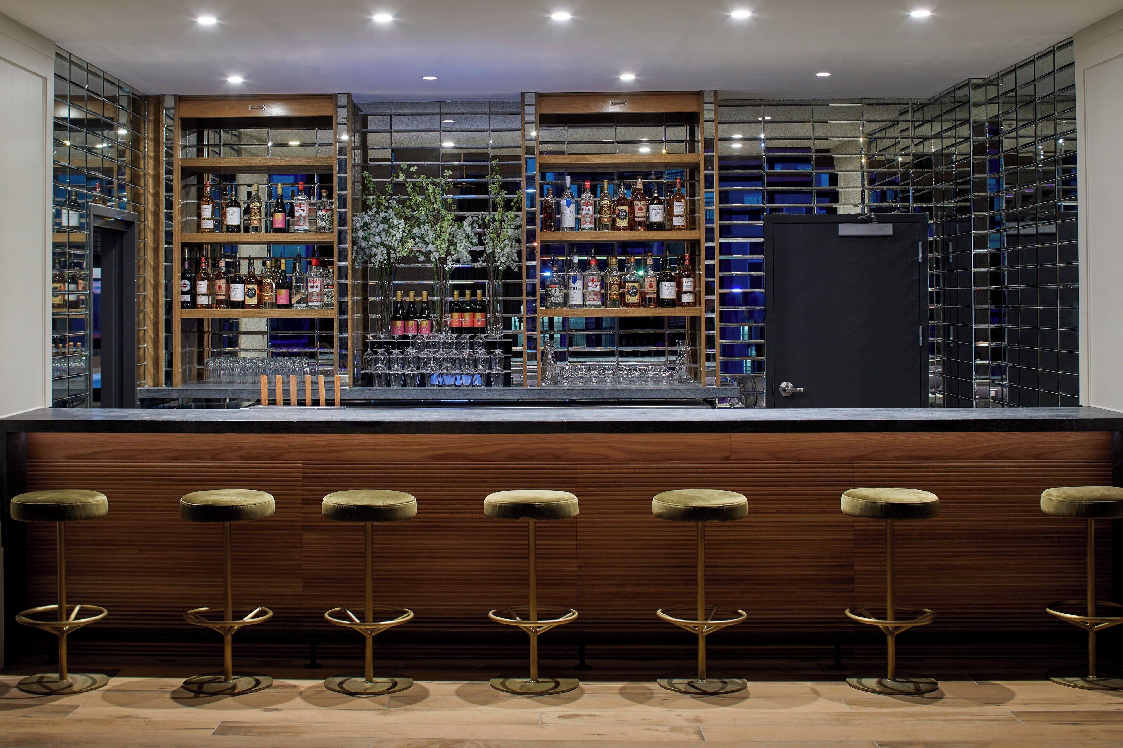 A bar area with wooden shelves and stools.