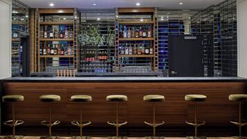 A bar area with wooden shelves and stools.