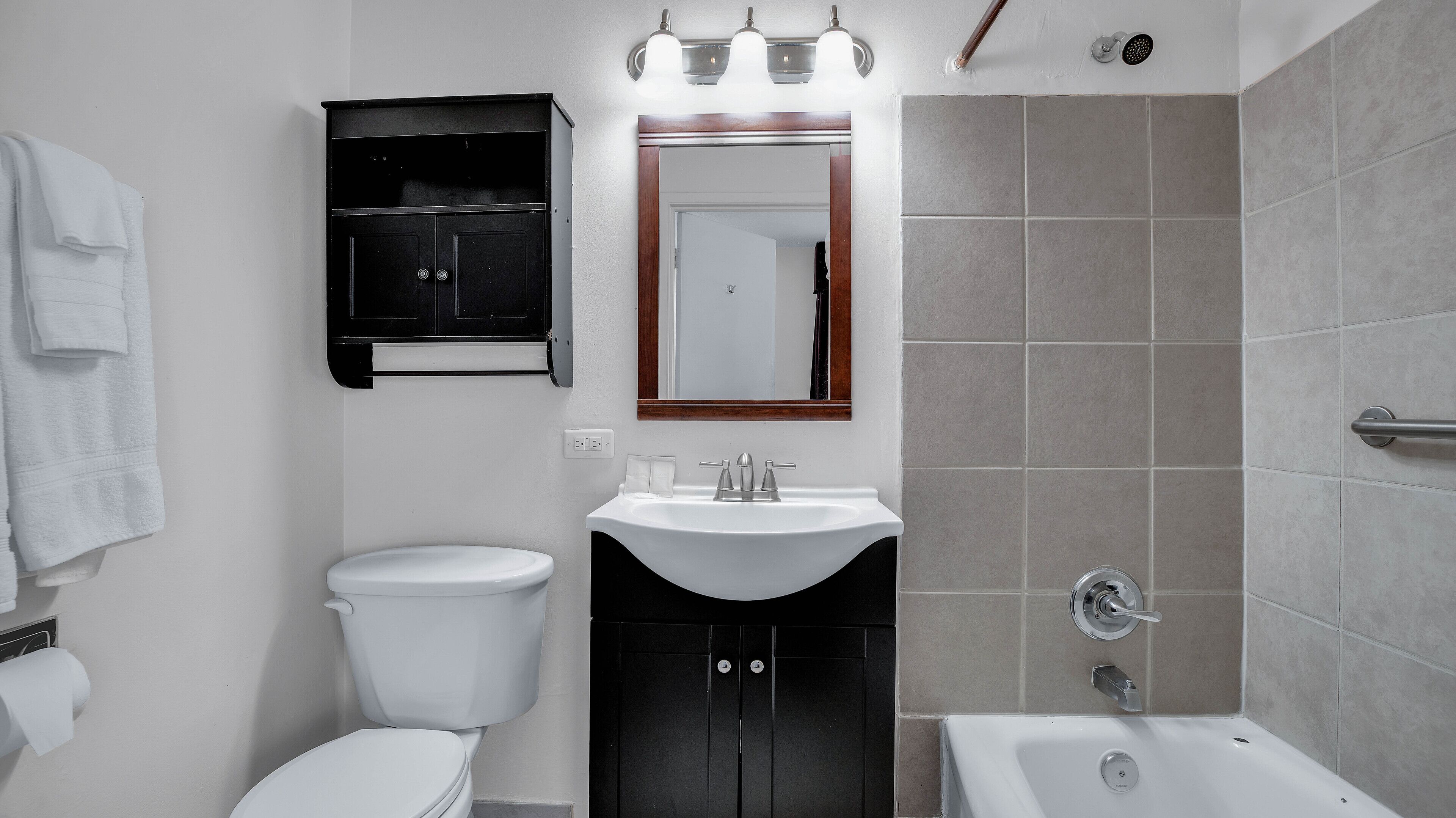 Een badkamer met toilet, wastafel en bad.