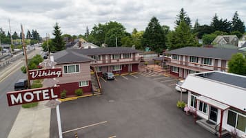 A motel with a parking lot, a TV sign, and a sign indicating vacancy.