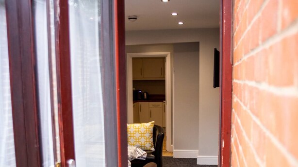 A narrow entryway leading to a kitchen area with cabinets and a countertop. - Stay Norwich Apartments 17Colgate (Norfolk)