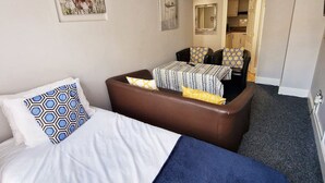 A hotel room with two beds, a sofa, a dining table, and a kitchen area. - Stay Norwich Apartments 17Colgate (Norfolk)
