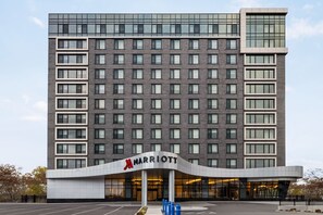 Un hotel Marriott de varios pisos con una fachada moderna, ventanas amplias y una entrada destacada.