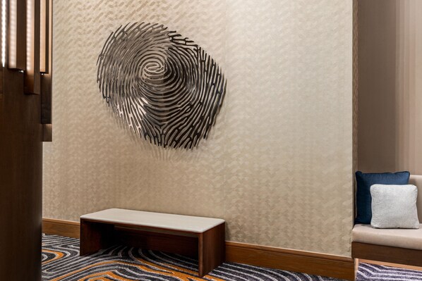 A modern interior with a patterned wall, a bench, and a sofa with cushions.