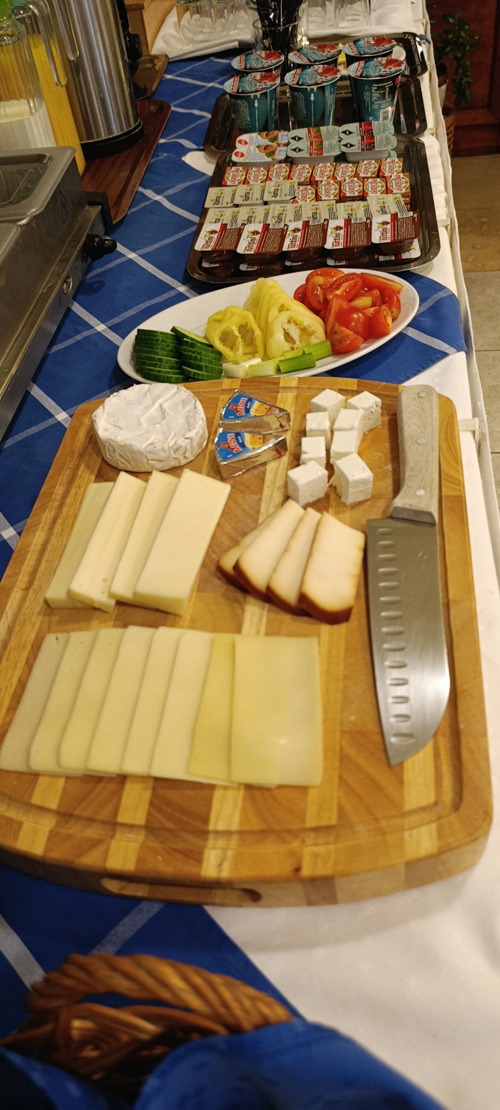 Noutopöytä, jossa on tarjolla erilaisia juustoja, hedelmiä ja lisukkeita.
