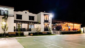 Un edificio moderno con una cancha de tenis al frente.
