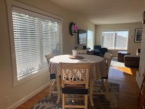 A dining area with a round table, chairs, and a vase with flowers. - Trinidad Harbor Ocean Views l 2 Bedrooms 2 Bathrooms (Trinidad)