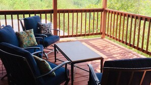Un espace extérieur abrité, doté d’une table et de chaises, offrant une vue sur un paysage pittoresque.