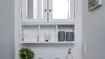 Een bad/douchecombinatie, een haardroger, handdoeken, zeep