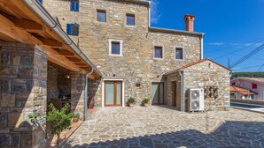 Un bâtiment en pierre doté d’une cour intérieure, où se trouve une petite boutique équipée d’un climatiseur.