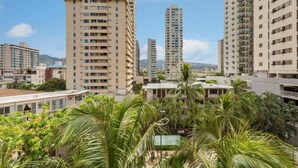 Un ensemble d’immeubles résidentiels de grande hauteur, dotés de nombreux balcons et offrant une vue sur des palmiers.