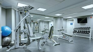 A gym with various exercise equipment, including weight machines and dumbbells.