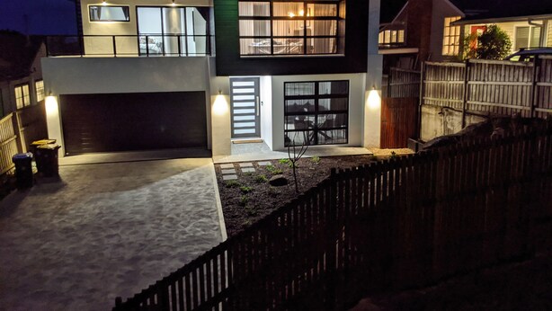 A modern two-story house with a garage, a front porch, and a wooden fence. - Seaforth Retreat (Seaforth)