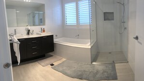 A modern bathroom with a glass-enclosed shower, a white sink, and a large mirror. - Seaforth Retreat (Seaforth)