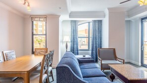 Ein Hotelzimmer mit Holztisch, einer Couch, einem Sessel und einem kleinen Tisch.
