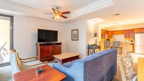 Una sala de estar moderna con una televisión, un mueble de madera y un sofá azul.
