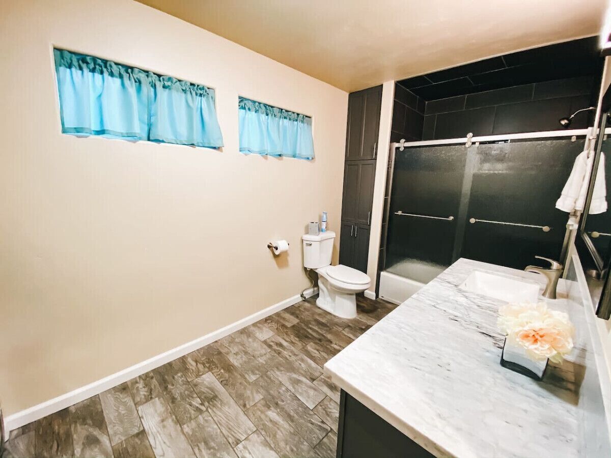 A bathroom with a toilet, sink, and shower area.