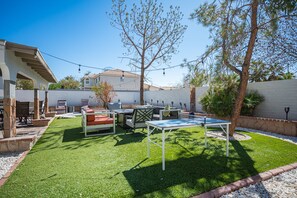 A backyard with artificial grass, outdoor furniture, and a pergola. - Luxury by the strip 5 star home close to LVB and airport. Great family home. (Henderson)
