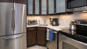 Une cuisine moderne dotée d’appareils électroménagers en acier inoxydable, de meubles en bois et d’un four à micro-ondes.