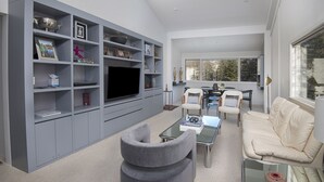 A modern living room with a grey entertainment unit, a flat-screen TV, a sofa, and a coffee table. - Ski-in/ski-out condominium at the base of Vail Mountain. Best location, pool!! (Vail)