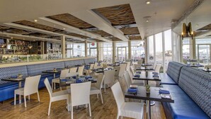 Ein Restaurant mit hohen Decken, einer Bar und Sitzgelegenheiten mit Blick.