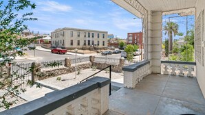 A balcony with a view of a street, a building, and a palm tree. - 3 story home near downtown El Paso  (El Paso)