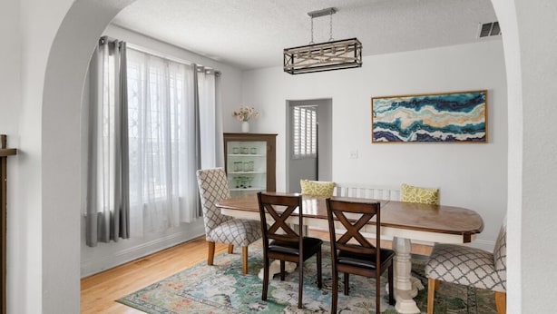 A dining area with a wooden table, four chairs, a chandelier, and a painting on the wall. - 3 story home near downtown El Paso  (El Paso)